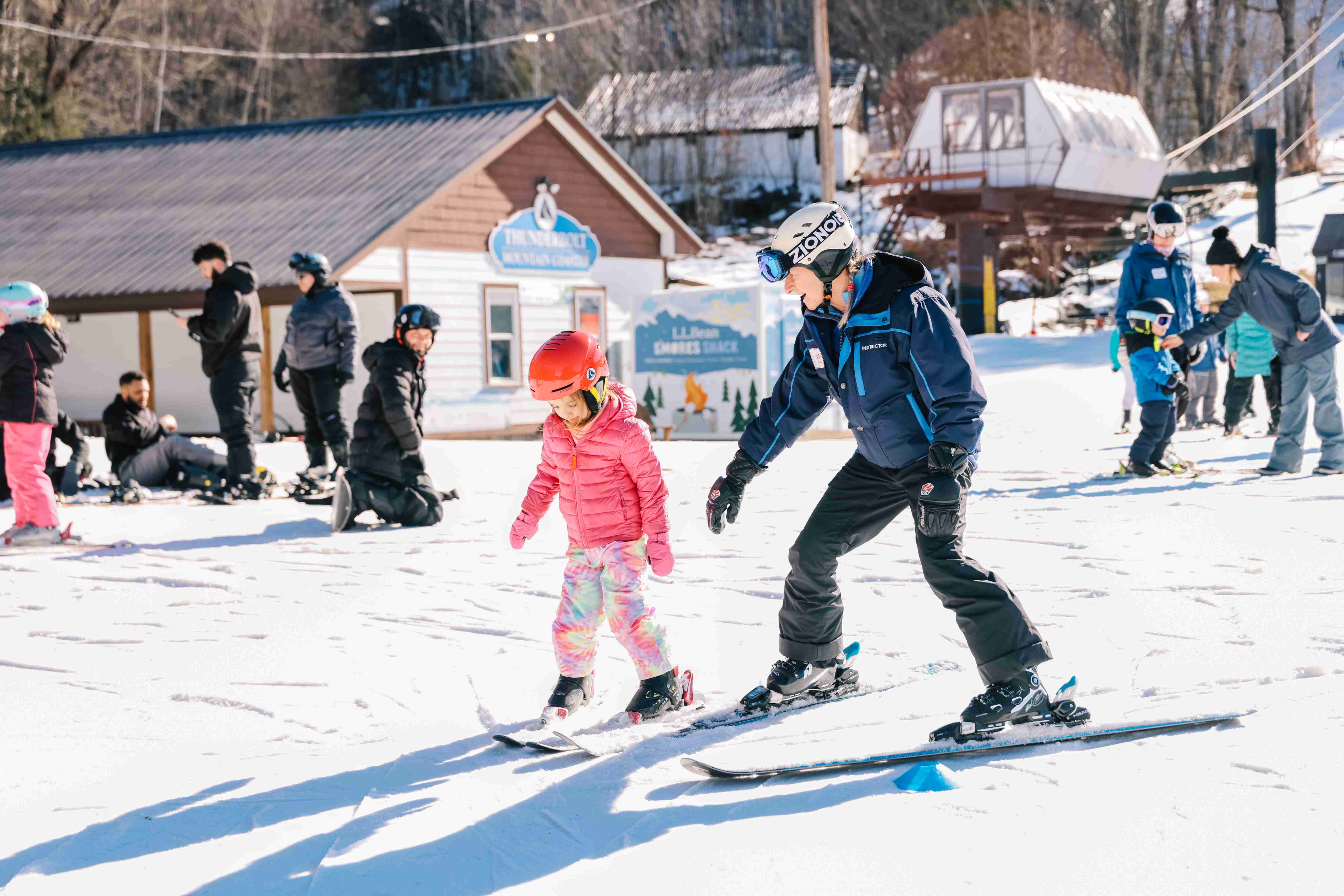 Ski Instructor helping a child on skis.